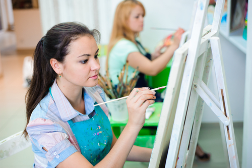 two women painting on easels
