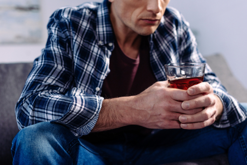 man holding glass of alcohol