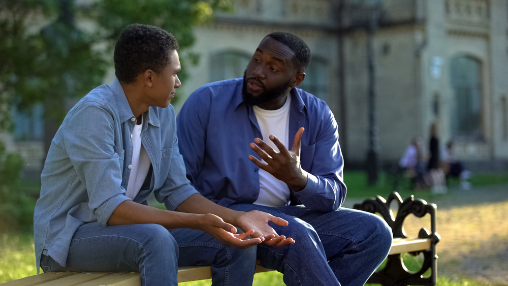 adult man talking to young adult son